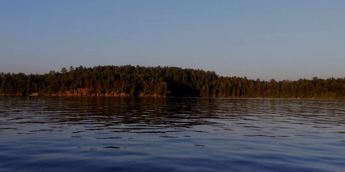 Moore Lake at dusk, the far shoreline reflected in still water